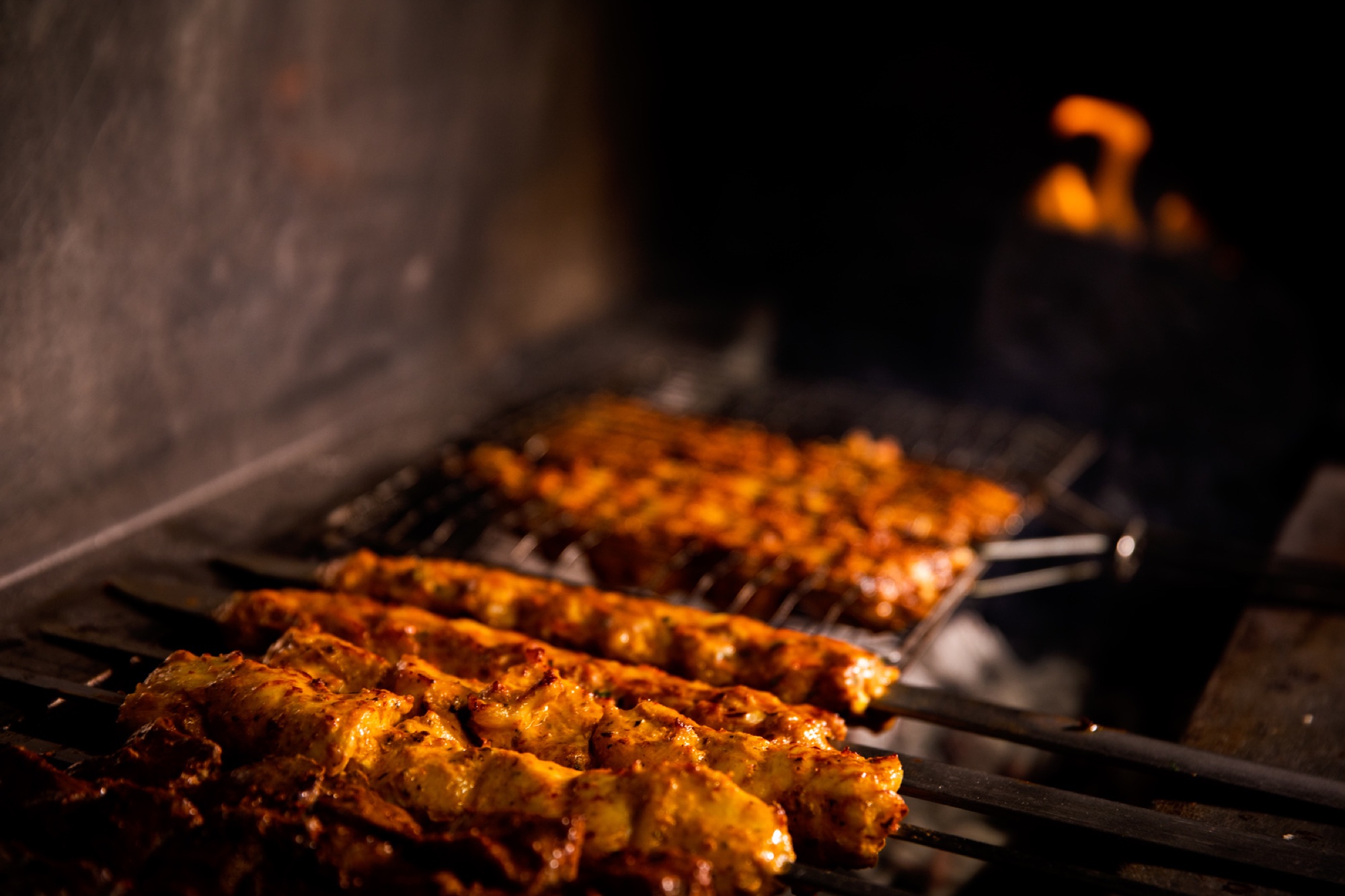 Skewers cooking over charcoal in the North Star kitchen