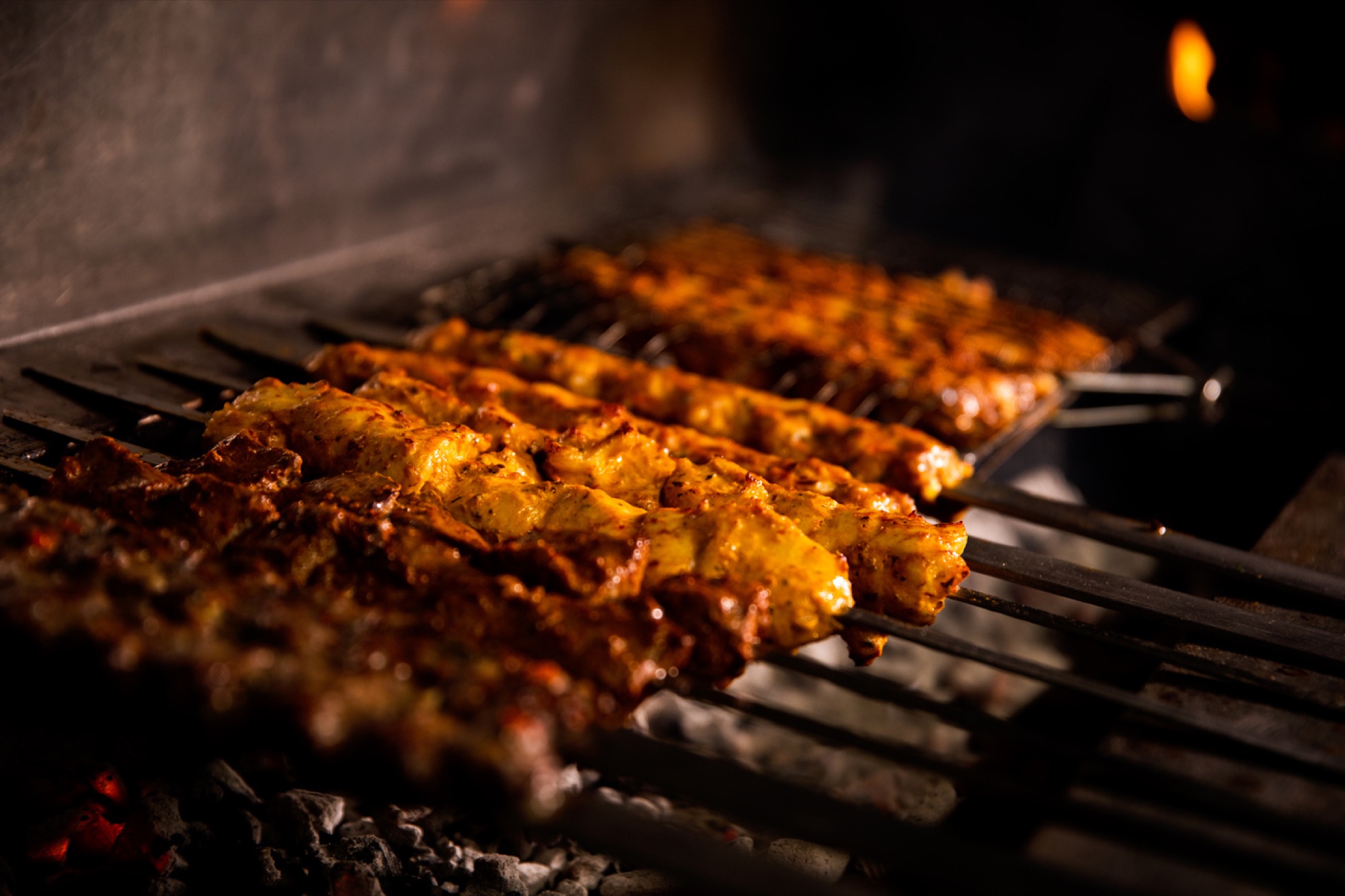 Marinated skewers cooking over charcoal at North Star